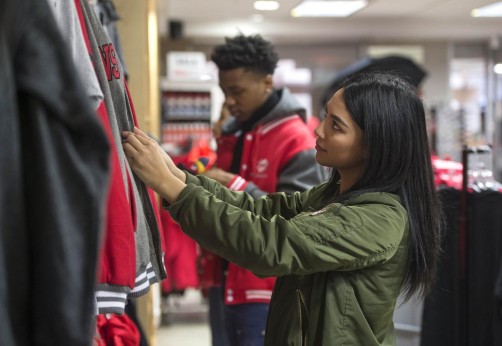 A student looking through sweaters at the falcon shop