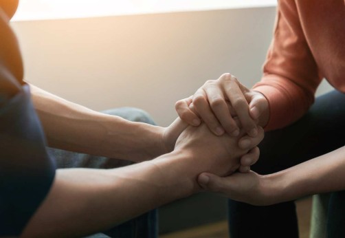 two people clasp hands