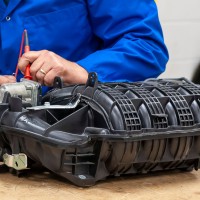 Student testing diesel engine intake part