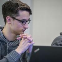 Student in computer lab, looking at laptop screen