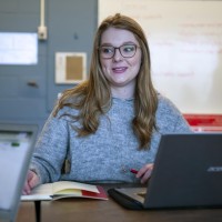 Business Administration Marketing student, sitting at conference table with laptop