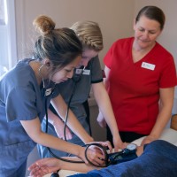 Two students learning from PSW teacher
