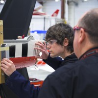 Aviation Technology - Aircraft Maintenance and Avionics student working with the help of instructor in lab