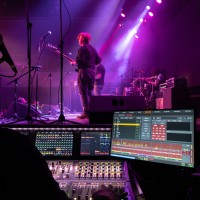 Student performing on stage with sound engineer on the side