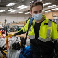 Paramedic student with practice patient on stretcher