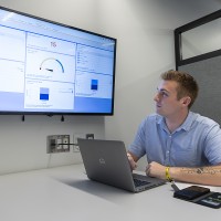 Student working on computer showing a presentation on screen