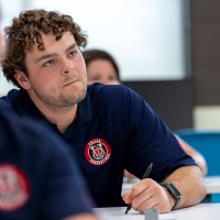 Police foundation student at desk with curious look on his face