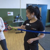 Fitness and Health Promotion student, doing arm exercises with band