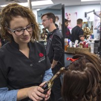 Fanshawe hairstyling student, curling hair of client