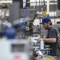 Mechanical Engineering Technician student, working in workshop at a large machine