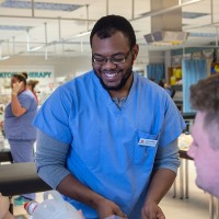 Male nurse student smiling with professor