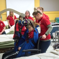 Students practicing with patient transportation device