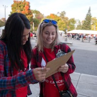 Two event planners working at a charity event with a clipboard in hand