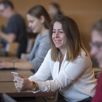 Fanshawe student smiling and sitting with other students in common area