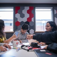 A group of students sitting at a table working on a project