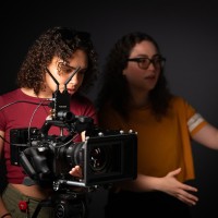 Film students look at a shot through a camera