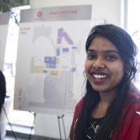 A student posing in front of their presentation