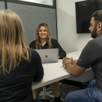 A female HR student practicing interview skills with two other Fanshawe students