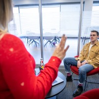 A male marketing student listening to a presentation at his co-op job