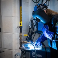 woman wearing a welding hood while welding