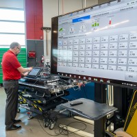 Green Vehicle Technician faculty member working on a car
