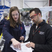 An instructor reviewing aviation information with a student in a flight hanger