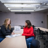 two women are sitting at the table