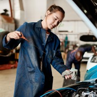 woman works on vehicle maintenance
