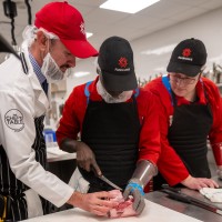 Students learning butchery techniques