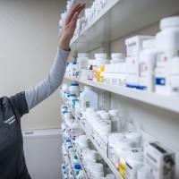 pharmacy assistant student organizes shelves of medication