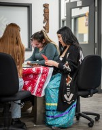 students sit around a table crafting