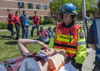 Students load an injured patient onto a stretcher during Trauma and Treatment weekend