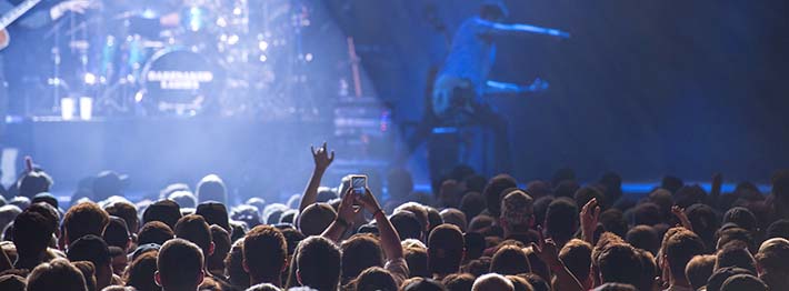 a crowd of people in front of a stage where a band is playing